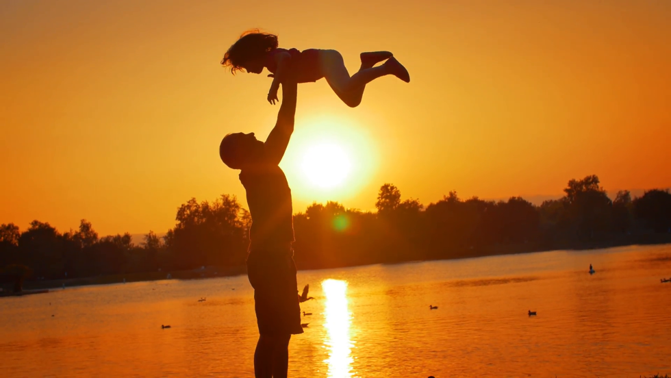 Dad with a child at sunset