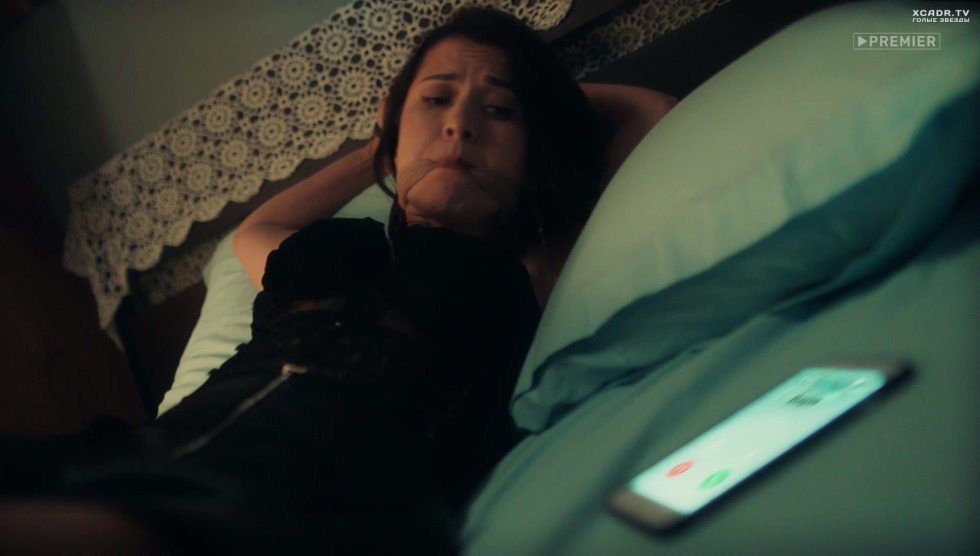 Anna Kuzina in handcuffs on the bed