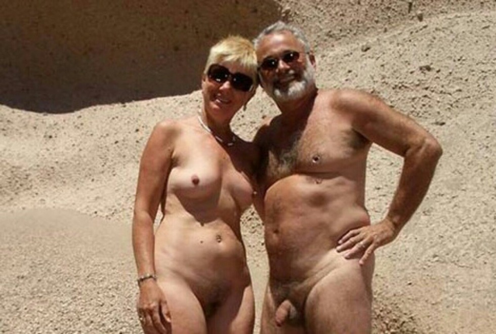 Nudists on the beach spread their legs