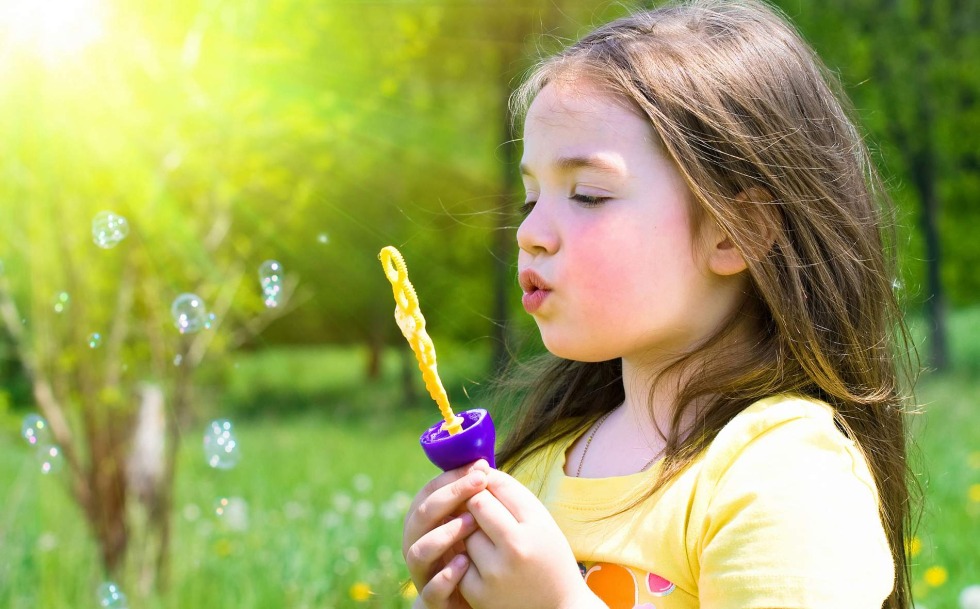 The child is blowing soap bubbles