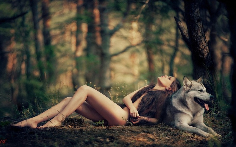 Girl with a wolf in the forest