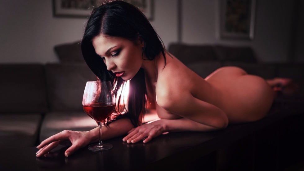 Naked woman with a glass of wine