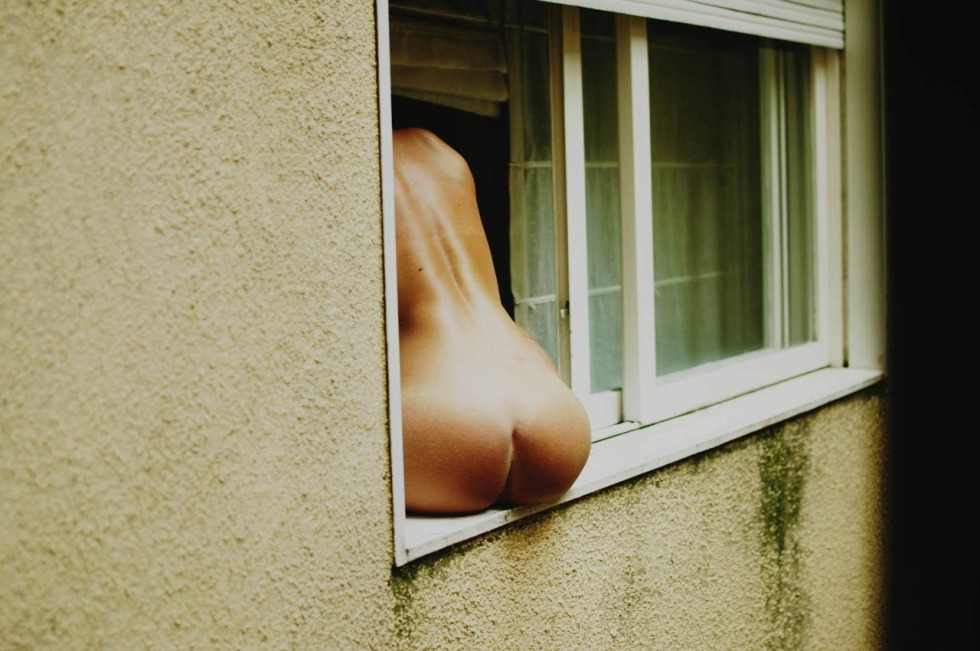 The girl undresses in the window