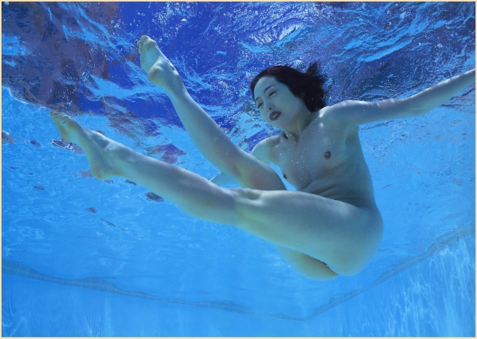 Naked women swim underwater