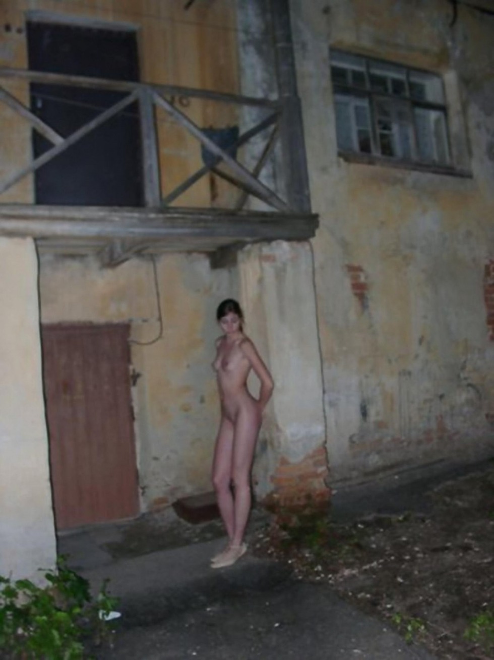 The girl undresses behind garages