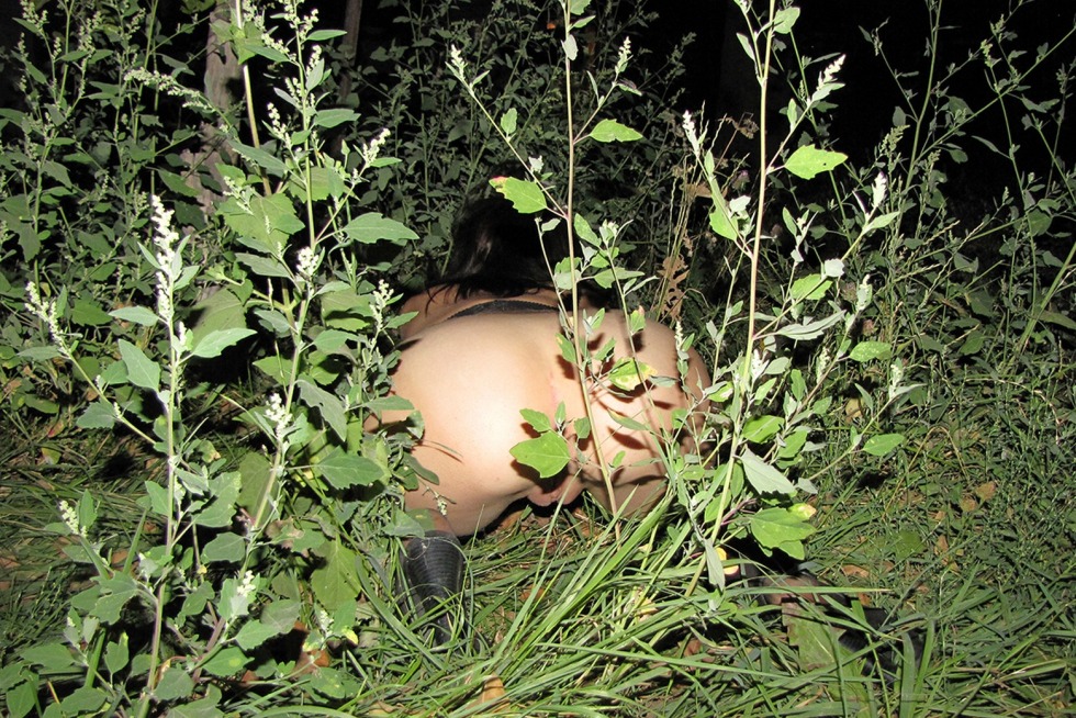 Naked woman is lying in the bushes