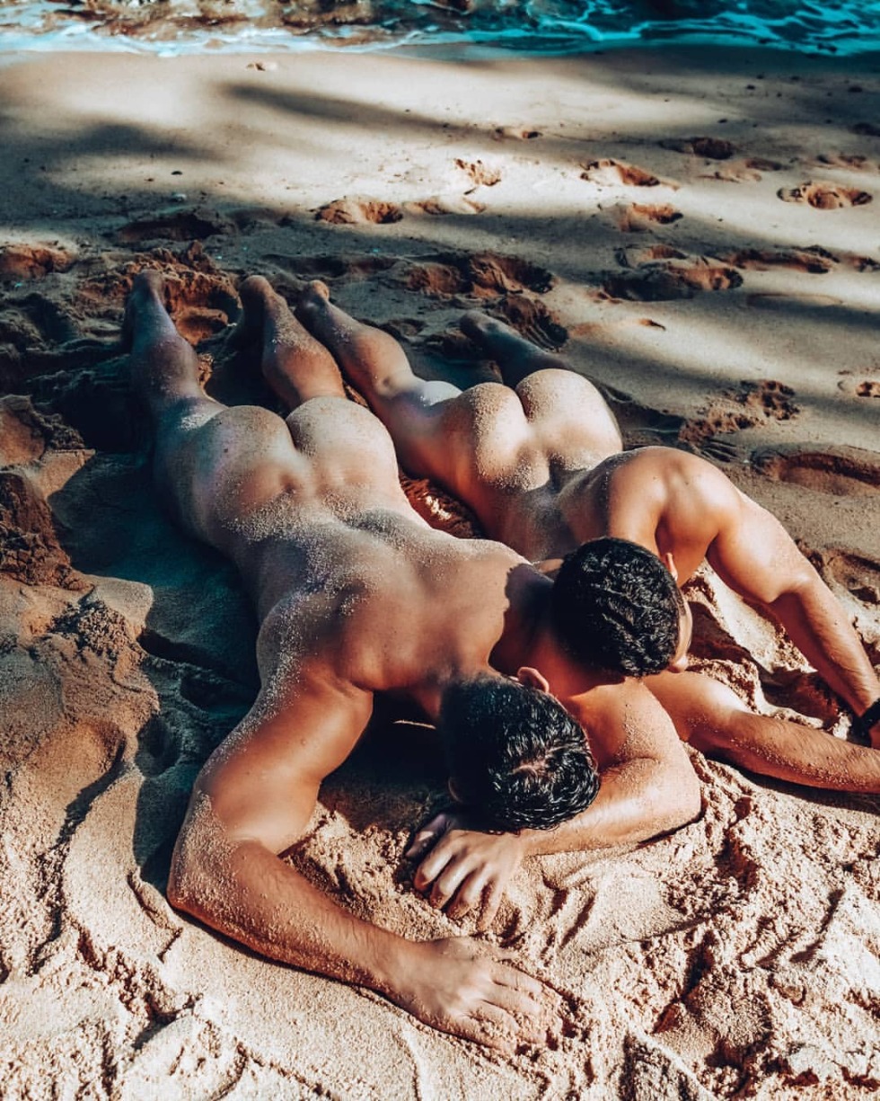 A naked guy lies on the beach