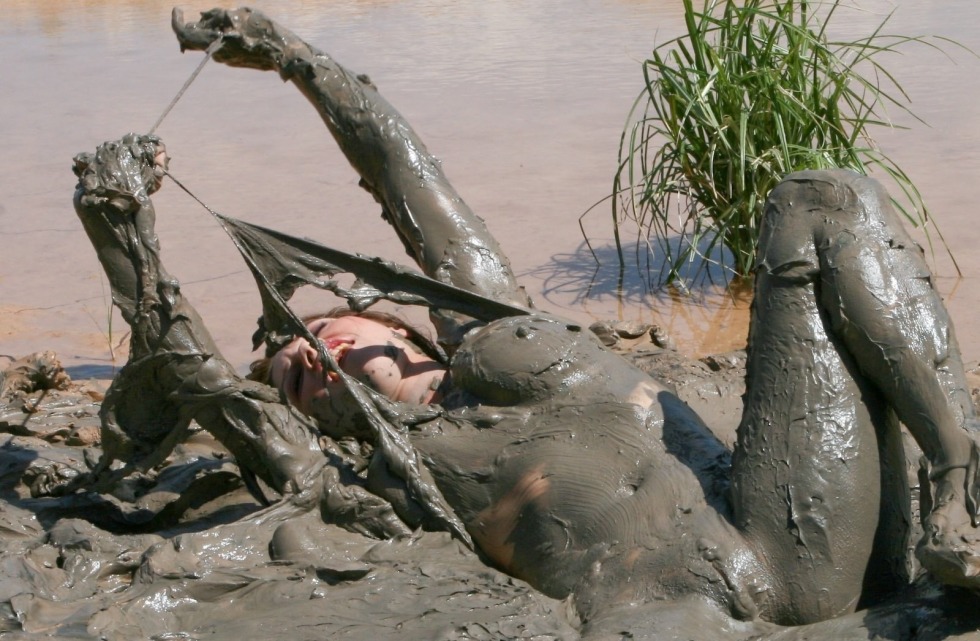 Naked women bathe in mud