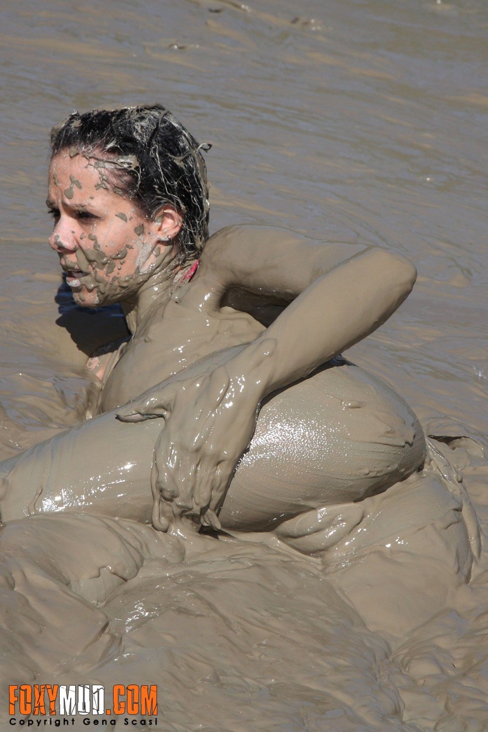 Naked guys bathing in mud