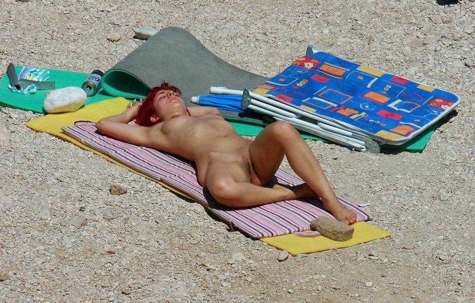 Nudist sunbathes on his stomach