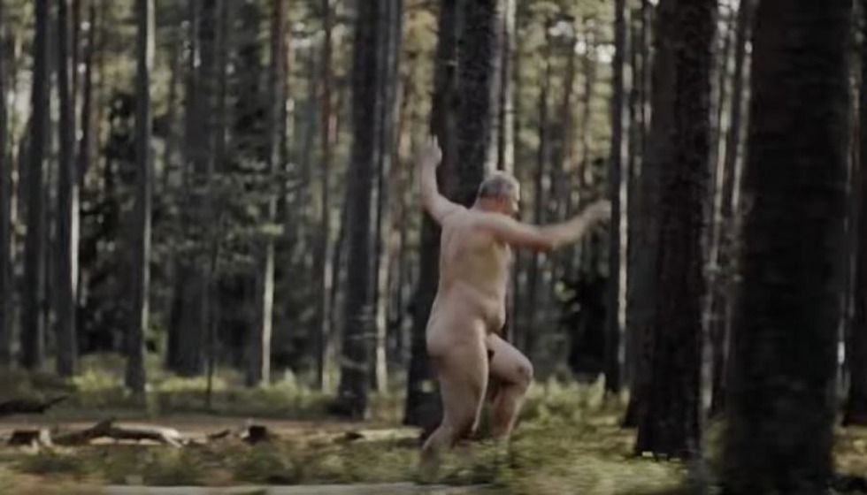 The boy undresses in the forest