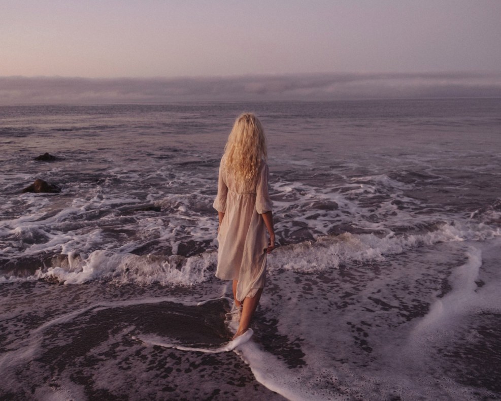 Blonde on the seashore from the back